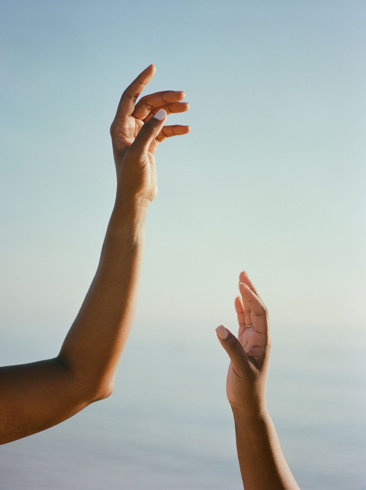 artist image of 2 feminine hands dancing on a sky background